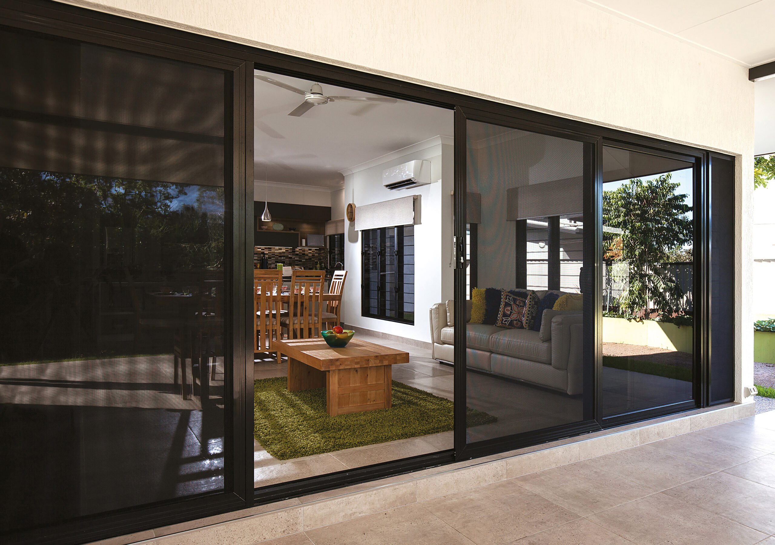 Sliding security doors installed on a modern home with outdoor patio